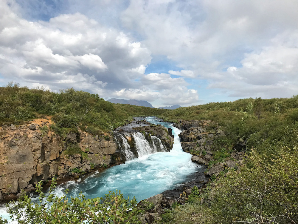 Hlauptungufoss, ein Wasserfall mit türkisfarbenem wasser