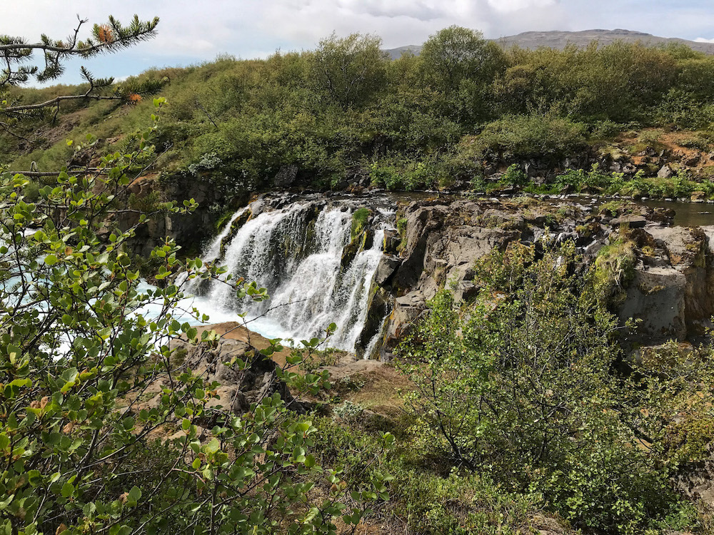 Hlauptungufoss, Wasserfall, der kaskadenartig über Steine fällt