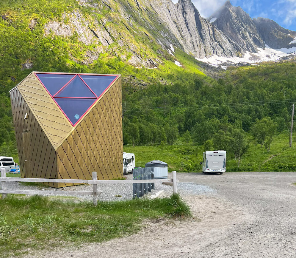 Häuschen mit Gold verkleidet und im Design eines Dreiecks vor steiler Bergwand