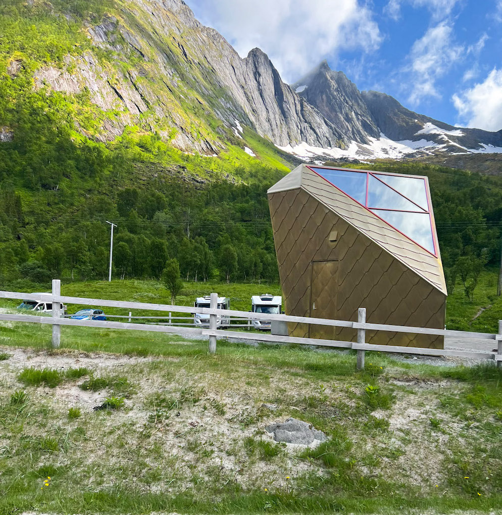 Häuschen mit Gold verkleidet und im Design eines Dreiecks vor steiler Bergwand