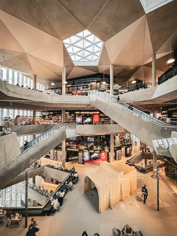 Innenraum der Deichmanske Bibliothek mit Rolltreppen und hellem Beton