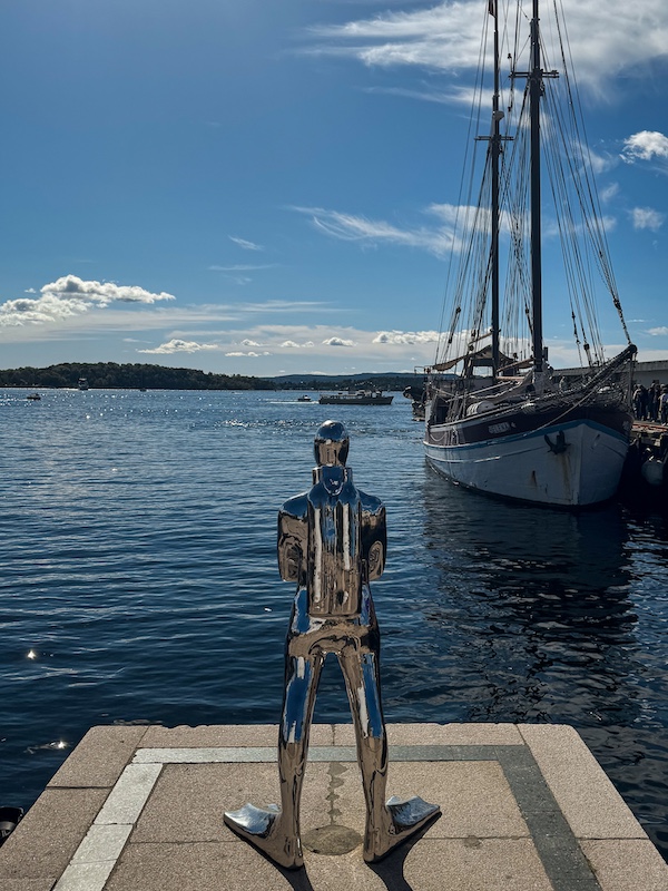 silberne Skulptur eines Tauchers vor dem Oslofjord mit einem Segelschiff