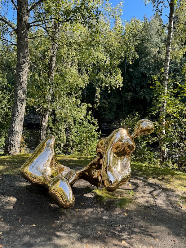 goldenes abstraktes Kunstwerk vor Wald in Kistefos