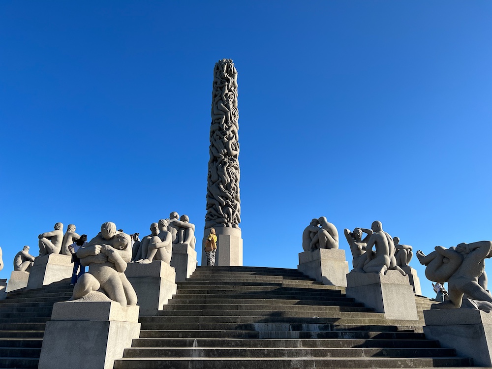 Skulpturen an Treppen, die zu einem Monolithen führen